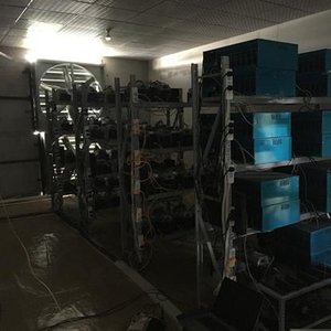A modern mining farm with rows of mining rigs connected with cables.
